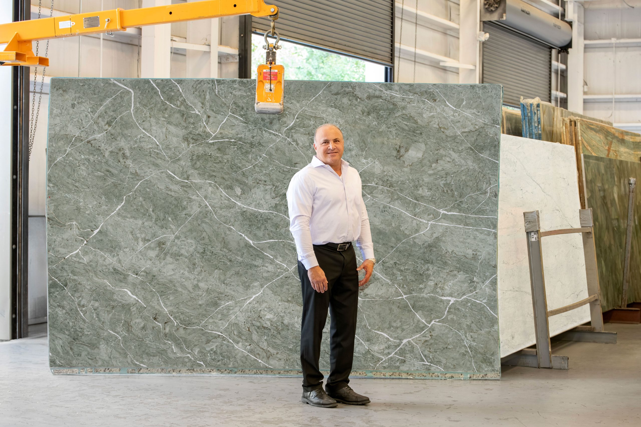 Donnie DiNorcia, president of UMI, standing in front of a slab in a warehouse