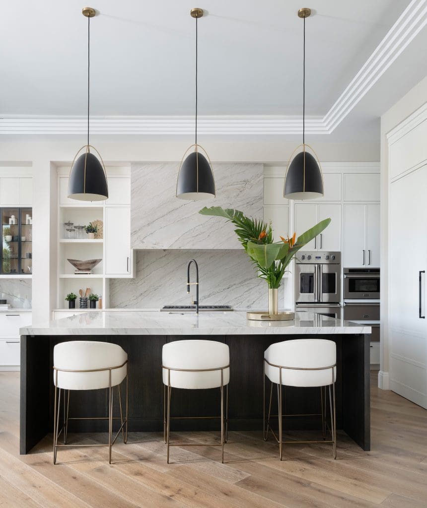 Modern kitchen with Bianca Quartzite island, black pendant lights, and white cabinetry.