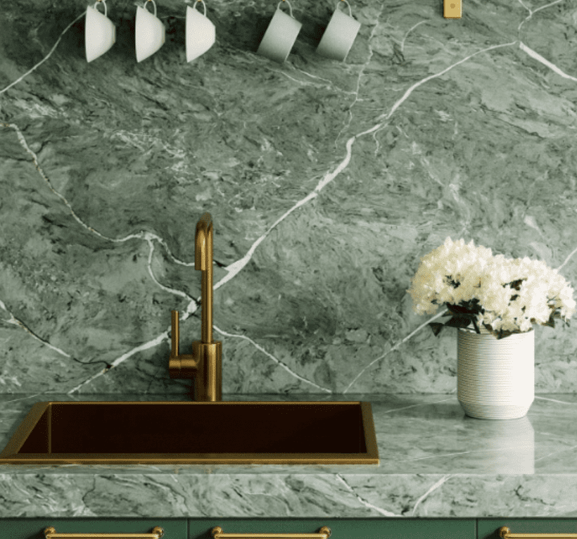 Elegant Pompeii Quartz Bonsai/ Vicostone Quartz Vitoria Regia kitchen with gold faucet, matching sink, and decorative white flowers.