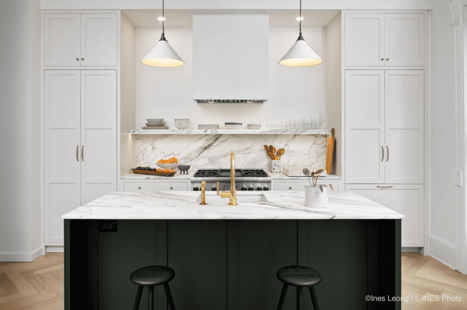 Modern kitchen with a sleek marble island countertop and black chairs.