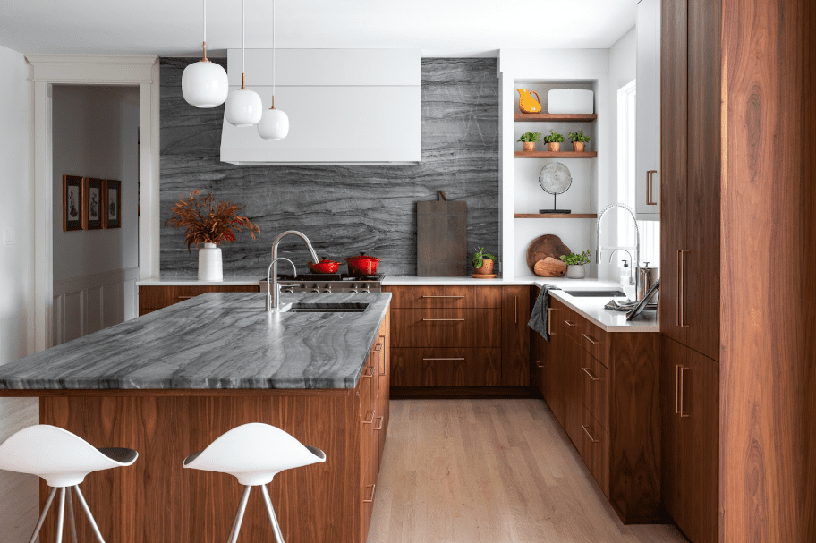 Modern kitchen with dark quartzite on island and backsplash, contrast with white perimeter countertop.