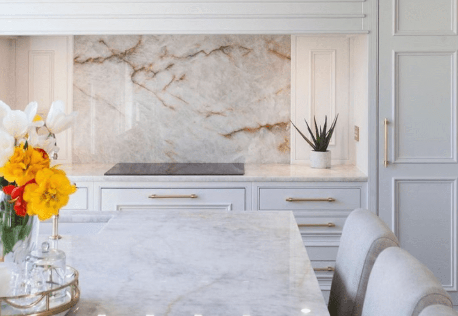 Elegant kitchen with Cristallo countertop and backsplash and sleek brass hardware accents.