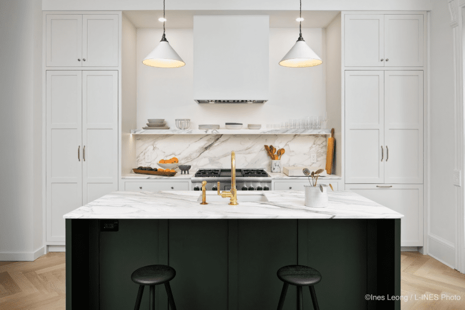 Modern kitchen with sleek white cabinets and dark island base with danby marble countertops and backsplash.