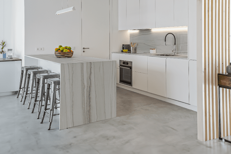 Image of a quartzite slab installed on a kitchen island and backsplash in the color Chantilly.