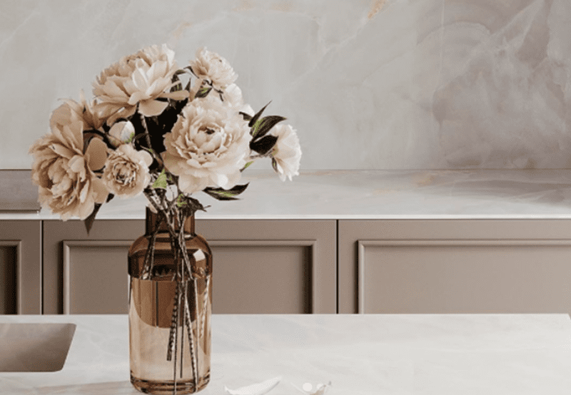 White porcelain countertops with soft veining and decorative floral arrangement.
