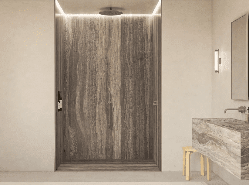 Travertine walk-in shower with dramatic veining and rainfall showerhead.