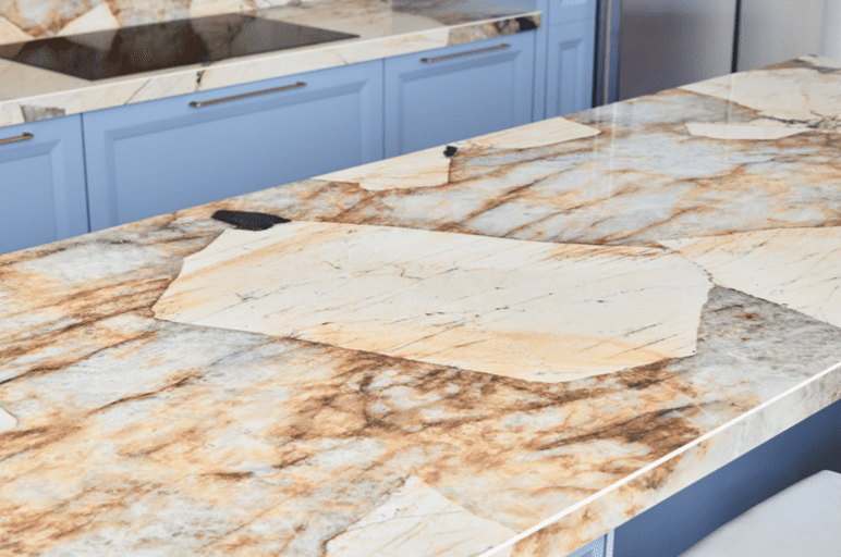 Striking Patagonia granite kitchen countertop with blue cabinets.