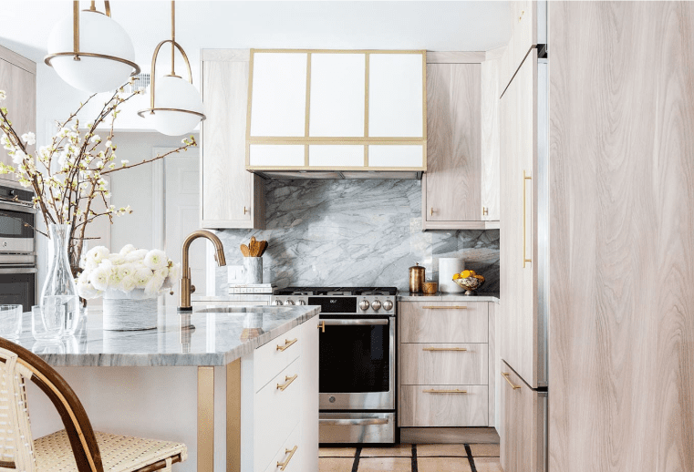 Kitchen with Ijen Quartzite countertops and backsplash, light wood cabinets, and brass hardware.