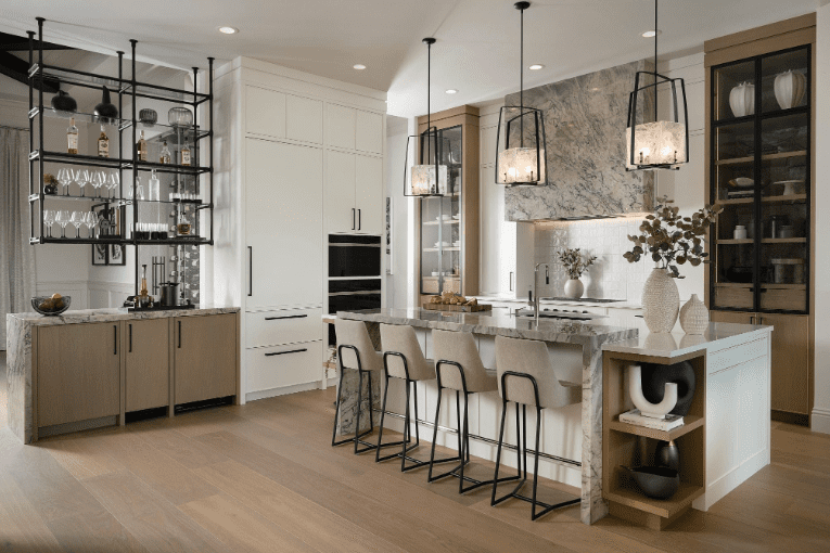 Open kitchen with quartzite island countertop and hood surround, white and natural wood cabinets, and black metal accents.