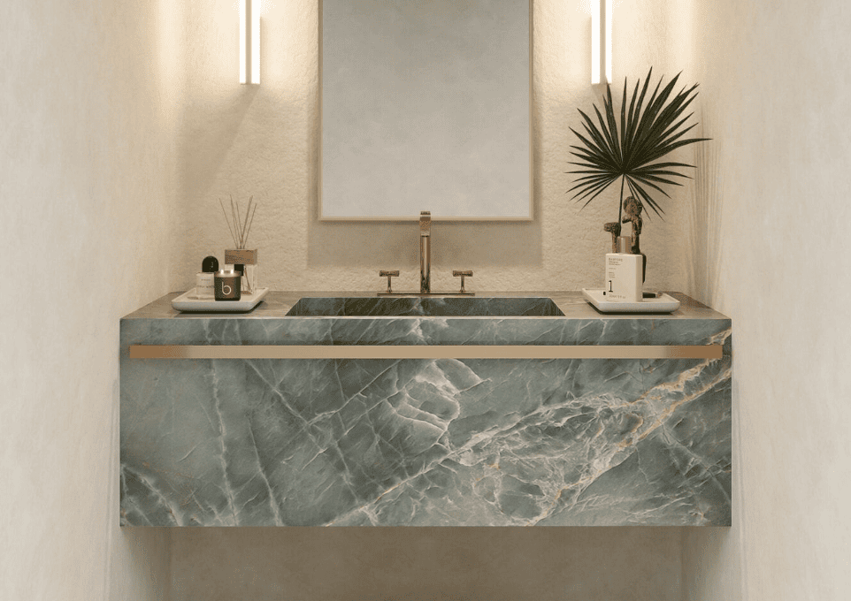Blue-green quartzite slab vanity with soft veining and brass accents. 