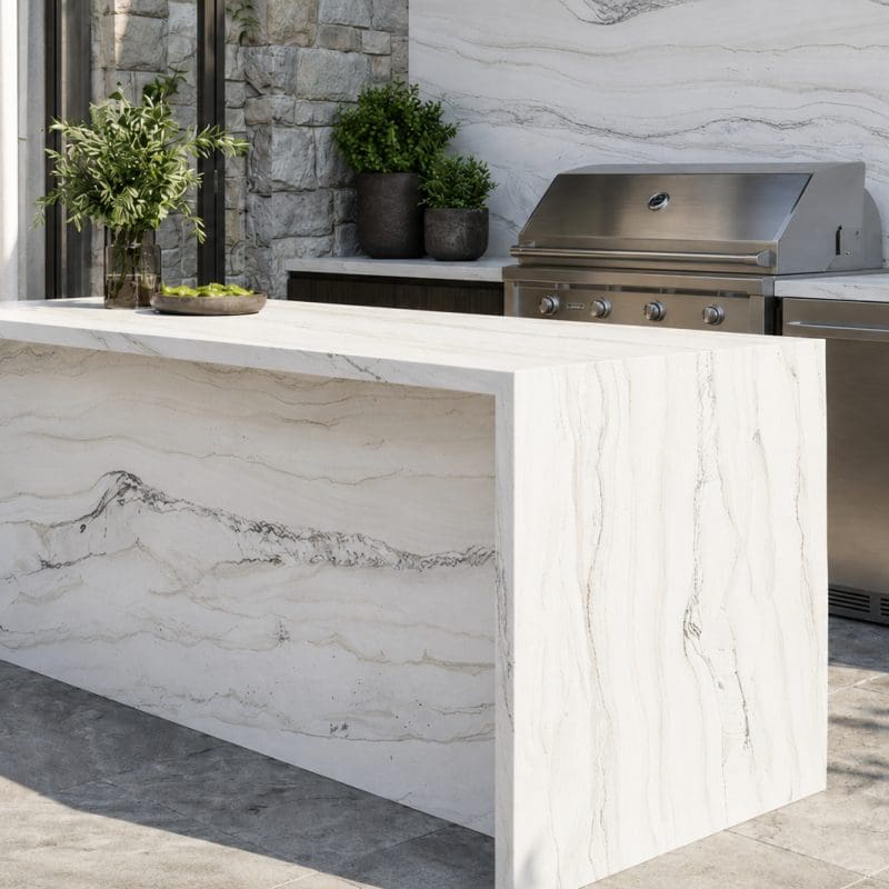Outdoor kitchen featuring a quartzite slab island, backsplash, and countertops with natural gray veining.