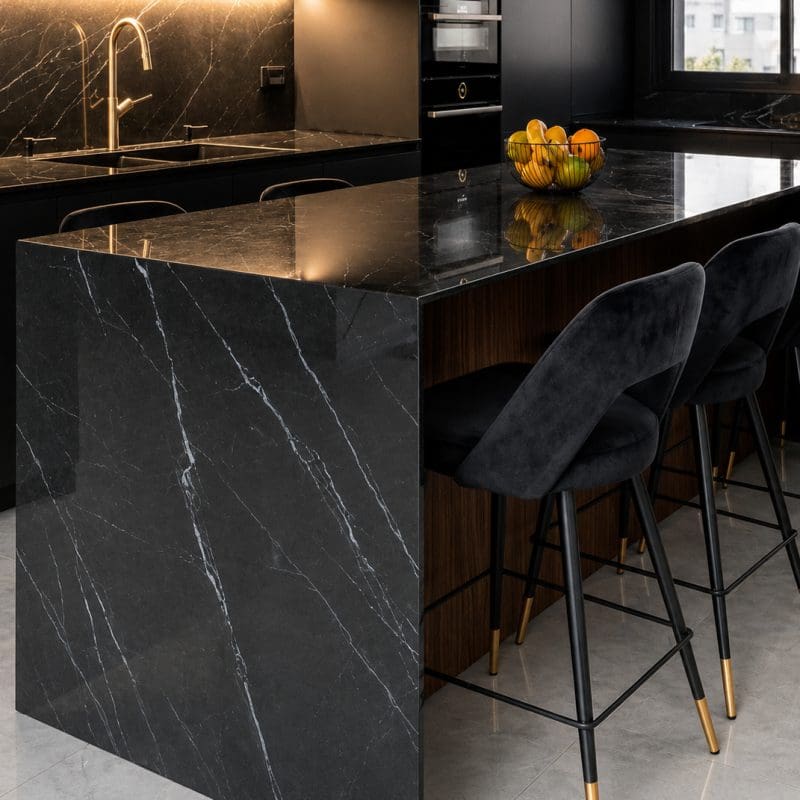 Modern kitchen featuring black porcelain countertops, backsplash, and waterfall island.