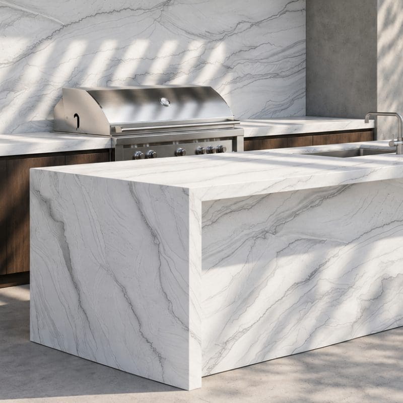 Outdoor kitchen with white natural stone waterfall island, matching backsplash, and a built-in grill.