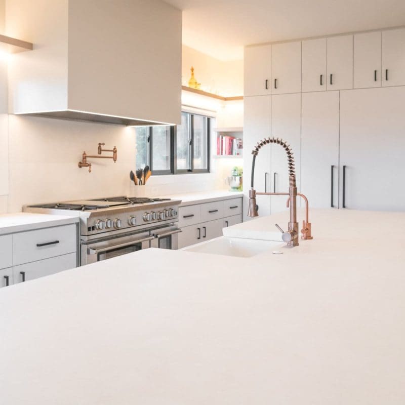 Modern kitchen with white matte quartz countertops and waterfall island.